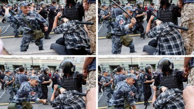 莫斯科周日的反政府退休改革计划示威中，俄罗斯国民卫队成员用警棍殴打示威者。