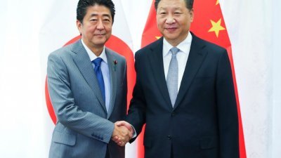 日本首相安倍晋三（左）与中国国家主席习近平在海参威举行会谈，习近平称冀推进两国关系发展。