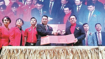 杨永明（左4起）在张润安的见证下，签署地南客家公会第21届理事会就职宣誓书后合照。