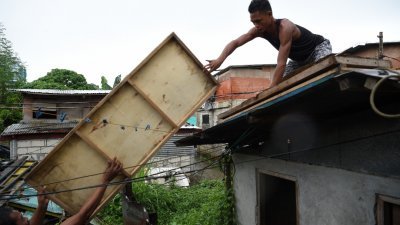 菲律宾东北部卡加延省的沿海地区民众，赶在超强台风“山竹”来袭前，为屋顶加固。