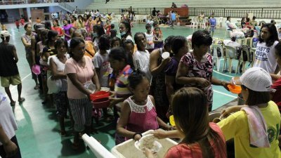强台“山竹”来袭，菲律宾卡加延省的一处疏散中心，民众有秩序地排队向中心工作人员领取食物果腹。