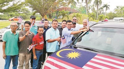 阿克玛（前排右）配合周日的马来西亚日，带领党员车队到新山国会选区进行公益慈善活动，探访选区内的慈善福利组织。