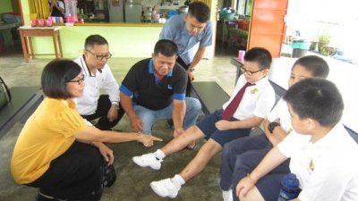 校长黄美（左起）、县议员黄文华及董事长李光发，细心检查学生小腿上被蚊虫叮咬的伤痕。