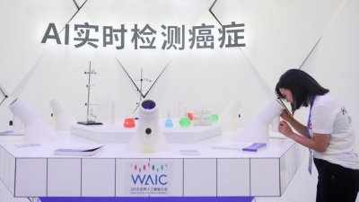 世界人工智能大会正在上海举行，大会以“人工智能赋能新时代”为主题。这是一名参观者在大会现场，体验“AI实时检测癌症”设备。