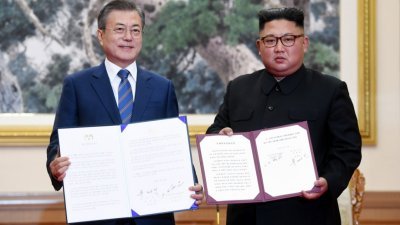 韩国总统文在寅（左）和朝鲜最高领导人金正恩向传媒展示签署的《平壤共同宣言》。