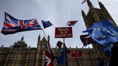 英国和欧盟都不肯退让，令脱欧谈判陷入僵局。这是英国民众早前在伦敦的国会大厦外，拿著“脱欧。是否值得？”的标语，以及英国国旗和欧盟旗帜示威。