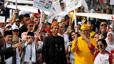 印尼总统佐科（中）和副手搭档马鲁夫周日穿著传统服饰，在众人簇拥下在雅加达市中心游行，为其竞选活动造势