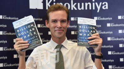 《华尔街日报》记者汤姆特莱（图），手持与同事布拉利霍普联手著作的《鲸吞亿万：愚弄华尔街、好莱坞及全球的人》一书。 （摄影：黄良儒）