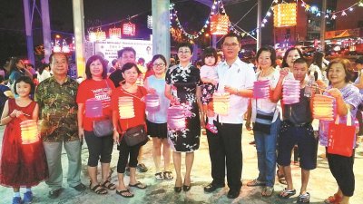 陈泓宾（左7）抱著女儿，与黄祥銮（左6）和民众一起提灯游街。