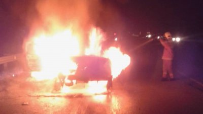 其中一辆涉事轿车在车祸现场燃起，火势猛烈。