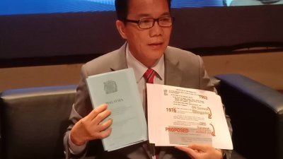 刘伟强在记者会上，展示及说明修改联邦宪法第1（2）条文 及修宪的目的。