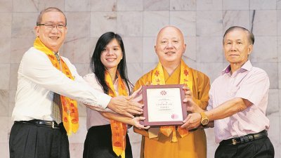 戴富来（左起）在张慧莹及释禅亮见证下，颁赠卓越服务精神奖给服务霹州分会已有42年的张瑞祺。