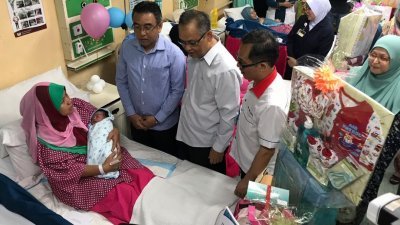 阿德里（站者左起）、曼苏及刘志良探访及赠送礼篮予刚诞下历史城纪念日宝宝的母亲。