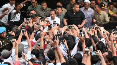 寻求连任的印尼总统佐科（中）在周三大选的投票结束后，在雅加达会晤支持者。（图片取自：法新社）
