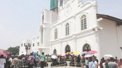 基督徒们顶著艳阳在教堂前排队准备进入教堂进行受难节聚会及弥撒。