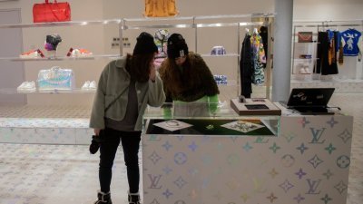 两名年轻人在北京市的奢侈品店的柜台选购。根据调查，中国人在境内外的奢侈品消费额，达到7700亿元人民币。