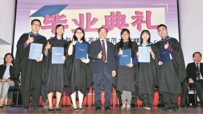 陈大锦（中）与2019年华文独中教育专业文凭课程的优等生合照。（摄影：伍信隆）
