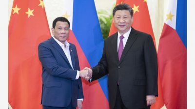 中国国家主席习近平（右）上周四在北京人民大会堂上，会见菲律宾总统杜特尔蒂，双方相互握手。（图取自：新华社）