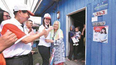 行动党候选人黄诗怡（中） 走访森森马来甘榜，获当地 村民热情拥抱。
