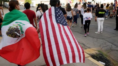 在美国得州艾尔帕索枪击案发生后，当地市民周日在案发现场的沃尔玛超市外，参加一项对抗仇恨的集会，两名出席者身上分别披著美国及墨西哥国旗，悼念在事件中遇难的两国公民。