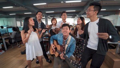 李伟纶与同事共同演唱《新加坡人的生活》。（图由受访者提供）