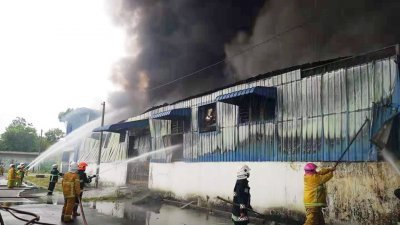 华都工业园一间家用塑料产品制造厂陷入火海，消拯员正在奋力灭火。