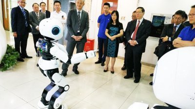 林冠英（右）率团参观深圳Canbot科技公司，与他们智能机器人合照。