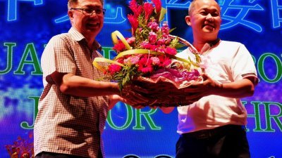 锺少云（左）周日晚上出席新山渔业批发商公会中元宴，获戴华山代表赠送水果礼篮。
