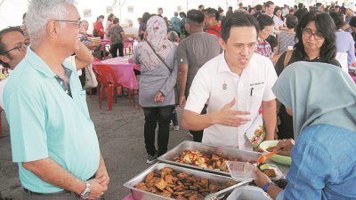 毕素（左起）和吴俊益巡视2019年国际无肉日慈善嘉年华的首个马来素食摊格。