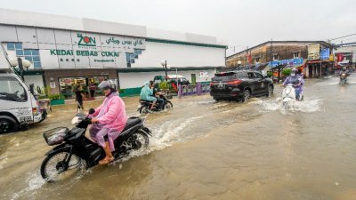 吉兰丹巴西马兰斗班让镇的哥乐河，因连日降雨以致河水高涨溢出，居民没有办法，只好骑乘摩哆涉水而过。