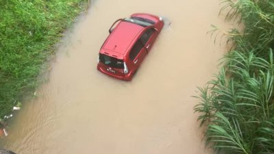 一辆红色国产迈薇轿车掉入河中，幸好女司机安全脱困。