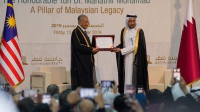 卡塔尔大学校长哈山阿德罕（右）向马哈迪颁发荣誉博士学位，以表彰他对学术界的贡献。