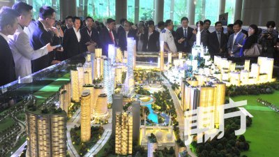 敦拉萨国际贸易中心城市有限公司与依海中铁（IWH-CREC）私人有限公司周二签署马来西亚城项目重启协议，图为出席者观看大马城项目规划模型，了解这项重大发展计划。 （摄影：邱继贤）
