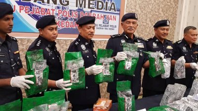 再努丁（左4）和警方高层展示毒贩藏在茶叶包装袋的冰毒，这批毒品市值180万令吉。（摄影：张瑞强）