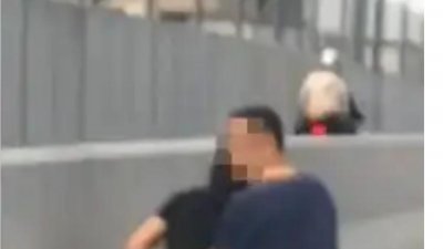 网传一则视频，一名女子疑人有三急但又遇到交通阻塞下，在疑是柔佛长堤路旁大解，让人傻眼。一名男子在旁掩护下。（图取自面子书）