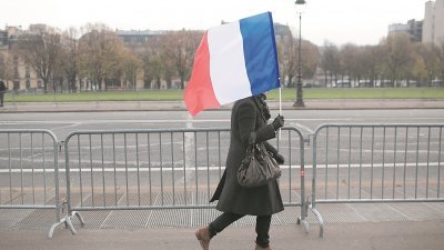 法国采取独立自主的外交、国防和经济政策，摆脱美国主导，从而维持法国的大国地位。图为法国首都巴黎，民众持著国旗走在街头。