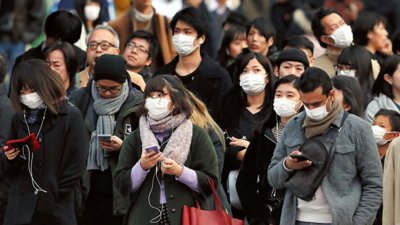 近日，日本遭到流感肆虐，据上周在日本全国医疗机构就诊的民众人数推算，流感患者已经增加到222万6000人，创下新高。这是红绿灯前，日本民众纷纷戴上口罩，以防感染流感。