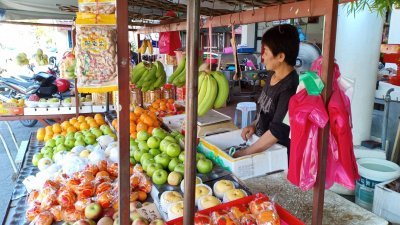 水果小贩感叹，生意一年比一年难做，年关已到，许多水果仍卖不出。