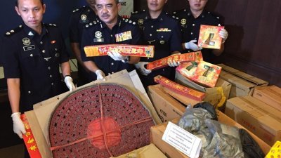 诺再尼（左2）展示警方起获71箱总值10万令吉的鞭炮和烟花。