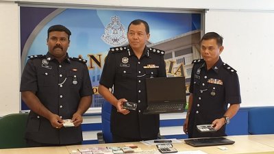 阿兹汉（左2起）及拉查里展示，警方在突击行动中起获的手提电脑及现金等。