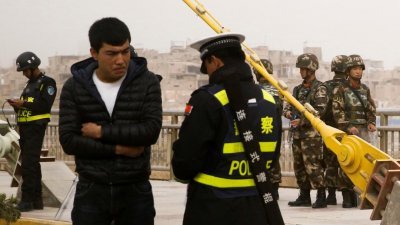 土耳其外交部上周六批评中国的新疆政策后，中国官媒《环球时报》周一和周二连续发文反击土耳其。这是中国警方早前在新疆喀什区，调查一名男子（左二）的身份证。