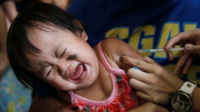 菲律宾马尼拉首都区奎松市一家医疗中心，一名儿童在打麻疹疫苗时放声大哭。目前全球各地区都出现麻疹疫情，数量和规模都在增加，世卫呼吁各国迅速采取行动对抗。