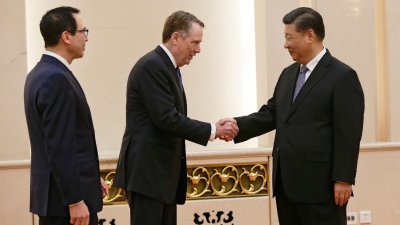 为期2天的中美贸易谈判在周五结束，中国国家主席习近平（右）在北京人民大会堂，会见与会的美国财政部长姆努钦（左），以及美国贸易代表莱蒂泽。