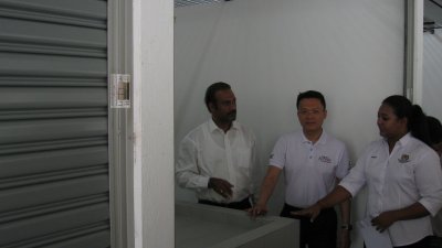蓝卡巴星（左起）、杨顺兴和维诺蒂妮一起参观垄尾 新巴刹的摊格。左边为小贩已自费装上卷门的摊格。
