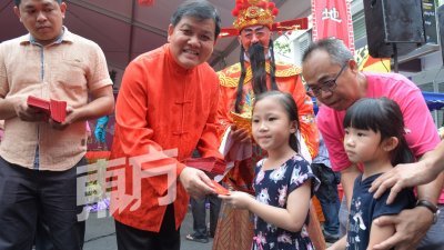 许来贤（左2）周日在蕉赖皇冠城举办“加影棒嘟嘟新春午宴”，与民一起欢庆农历新年， 现场也派发红包给小朋友。（摄影：曾钲勤）