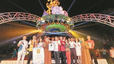 马来西亚纪录大全首席营运员黄枫伟（左5）周二把马来西亚纪录大全的证书，颁发给总住持觉诚法师（左4）、制灯团队以及主题灯的彩绘年轻画家颜知信（左3）。