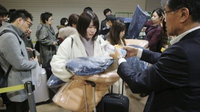 北海道周四的地震无造成严重伤亡，但导致约120名旅客无法离开新千岁机场。这是机场人员发给滞留在机场过夜的旅客每人一件毛毯、饮用水及食品等。