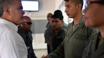 哥伦比亚政府在周日发布照片，总统杜克（左）欢迎向哥国投诚的委内瑞拉武装部队成员。