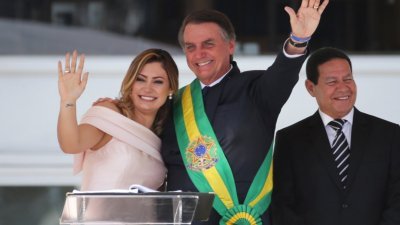 巴西新任总统博尔索纳罗（中）宣誓就职后，在夫人陪伴下在总统府普拉纳尔托宫，发表全国讲话，并向其支持者挥手致意。