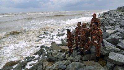 热带风暴“帕布”的登陆使半岛东海岸一带掀起强风巨浪，图为吉兰丹消拯局局 长纳兹利（右）与队员在哥打峇鲁的沙柏海边巡视大浪情况。